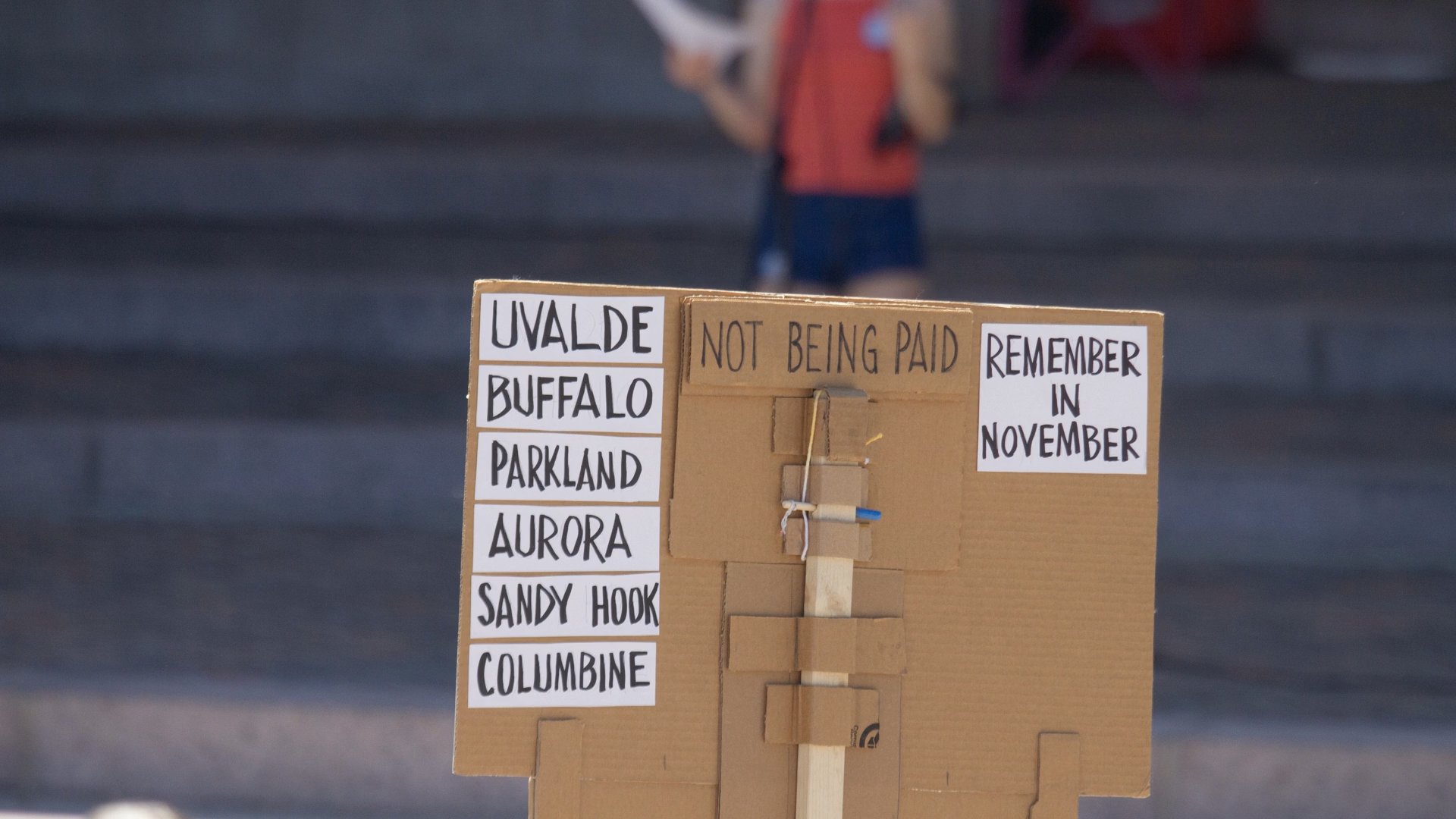 Cardboard sign listing mass shooting locations