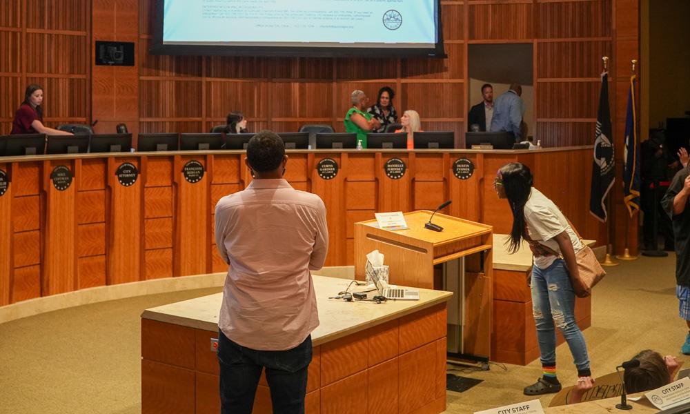 Community members stand at the podium addressing Aurora City Council