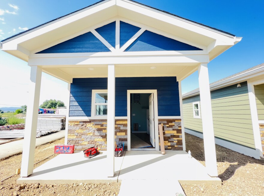 Exterior of one of the 26 tiny homes at Veterans Community Project in Longmont, with stone siding and a covered porch